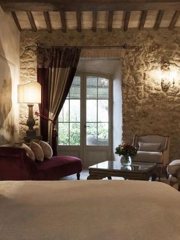 Elegantes Zimmer mit rustikaler Steinwand und gemütlichem Sofa im Borgo Santo Pietro Hotel