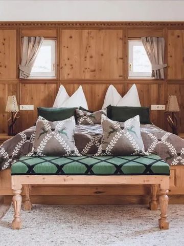 Schlafzimmer im alpinen Stil mit Holzelementen und gemusterten Kissen