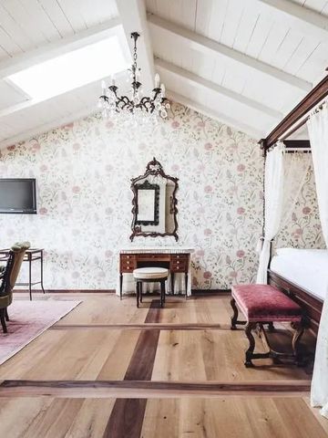 Luxuriöses Zimmer mit Himmelbett und floraler Tapete