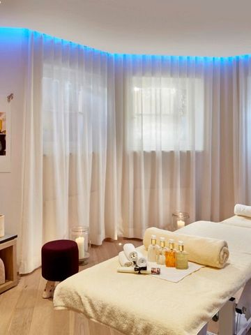 Wellnessraum mit Massagetisch und stimmungsvoller Beleuchtung im Relais & Châteaux Hotel Tennerhof.