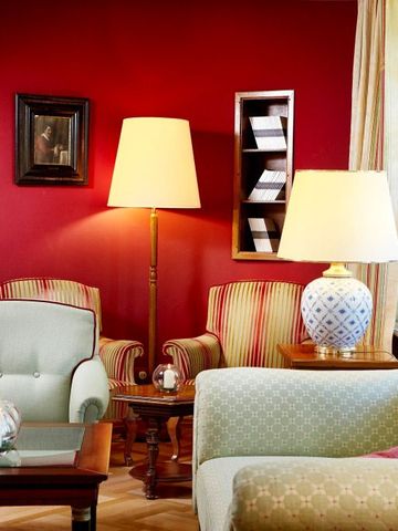 Gemütliche Lounge-Ecke mit roten Wänden und eleganter Beleuchtung