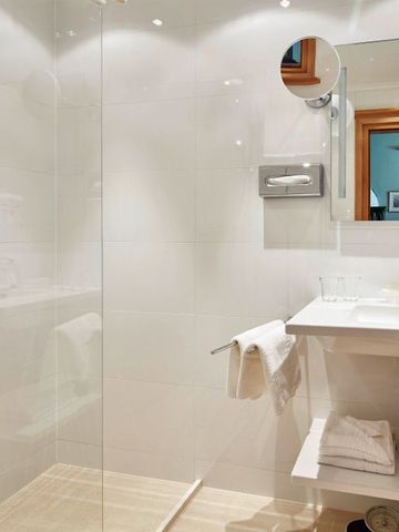 Geräumige Dusche und Waschbecken in elegantem Badezimmer