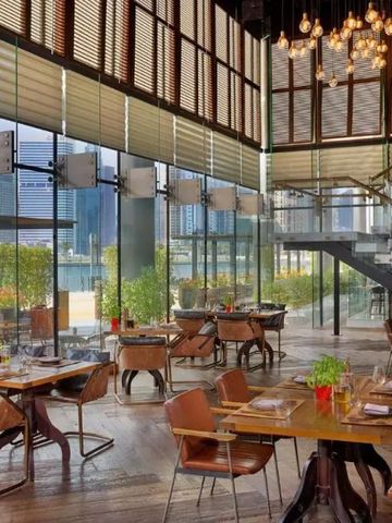 Helles Restaurant mit Glasfront und Blick auf die Stadt