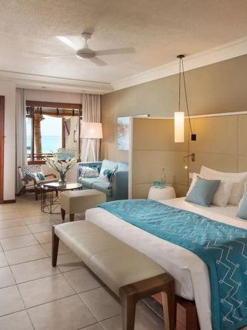 Luxuriöses Hotelzimmer mit Blick auf den Ozean und hellblauen Akzenten