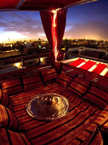 Traditionell dekorierte Dachterrasse mit Blick über die Stadt bei Sonnenuntergang