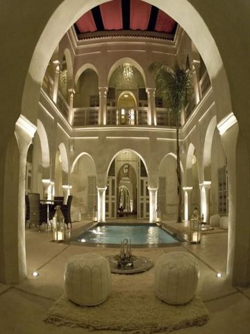 Beleuchteter Innenhof mit kleinem Pool und gewölbter Architektur