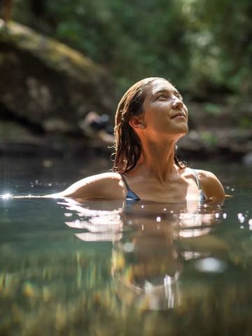 Frau genießt ein entspannendes Bad im natürlichen Fluss