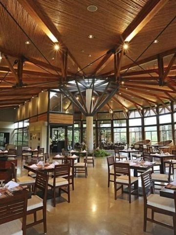 Geräumiges Restaurant mit Holzboden und moderner Decke aus Holz und Stahl.