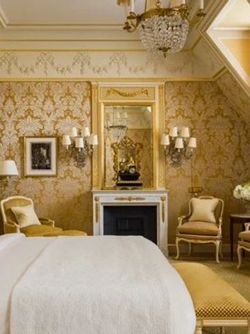 Opulentes Gästezimmer im klassischen Stil mit vergoldeten Details und Kamin