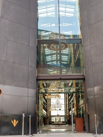 Eingang des Hotels mit moderner Glasfassade und hoher Lobby.