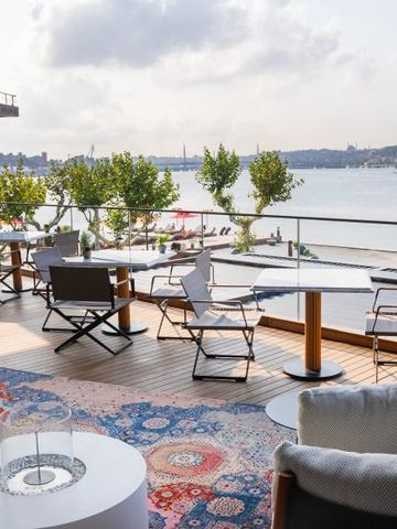 Terrasse mit Sitzgelegenheiten und Blick auf den Fluss.