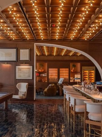 Luxuriöser Barbereich mit Billardtisch und stilvoller Beleuchtung.