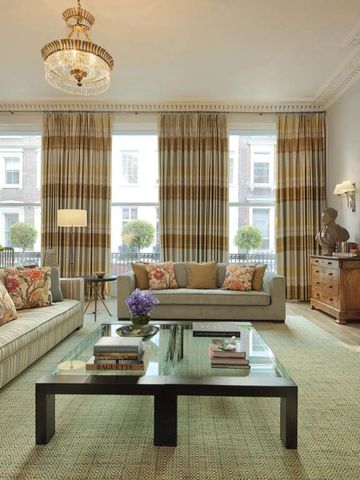 Geräumiges Wohnzimmer mit eleganten Sofas und großen Fenstern.