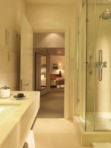 Helles Badezimmer mit Dusche und direktem Zugang zum Schlafzimmer.