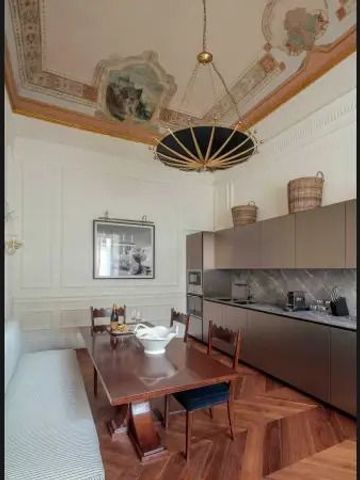 Elegante Küche mit Holztisch und kunstvollem Deckenstuck