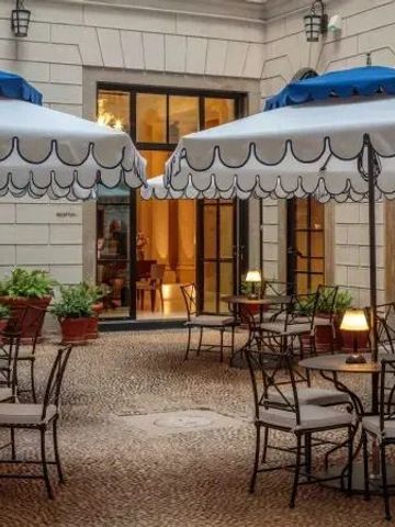 Stilvoller Innenhof mit Tischen und dekorativen Sonnenschirmen