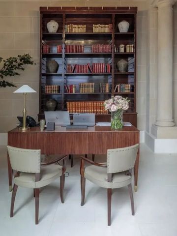 Elegante Bibliothek im Hotel mit Vintage-Regalen und Bücherstapeln.