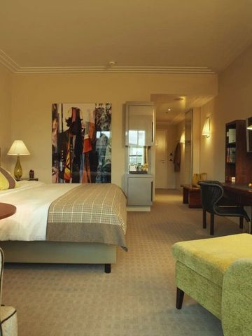 Gemütliches Hotelzimmer mit großzügigem Bett und stilvollen Möbeln.