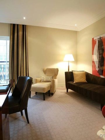 Gemütliche Sitzecke in einem Zimmer mit Kunstwerk und Schreibtisch.