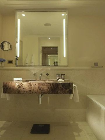 Modernes Badezimmer mit großem Spiegel und edlem Waschbecken.