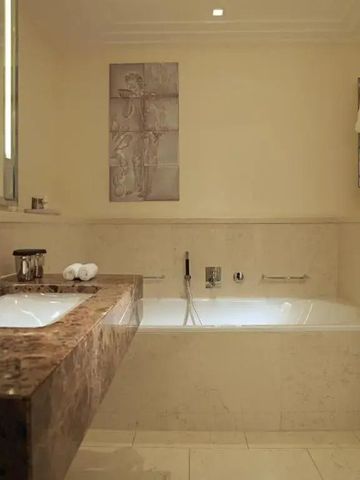 Geräumiges Badezimmer mit Badewanne und eleganten Oberflächen.