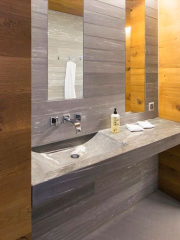 Badezimmer mit Waschtisch und Holzverkleidung im Hotel
