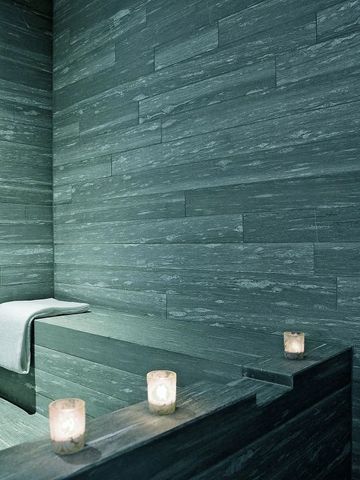 Dampfbad mit grauen Fliesen und dekorativen Kerzen im Hotel