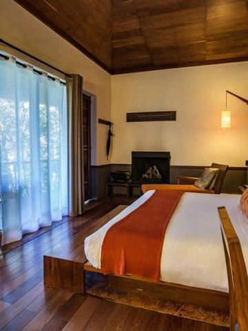 Geräumiges Schlafzimmer mit Holzboden, Kamin und großem Bett