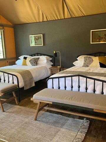 Gemütliches Zimmer mit zwei großen Betten und rustikaler Dekoration