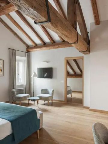 Geräumiges Zimmer mit freiliegenden Holzbalken und gemütlichem Doppelbett