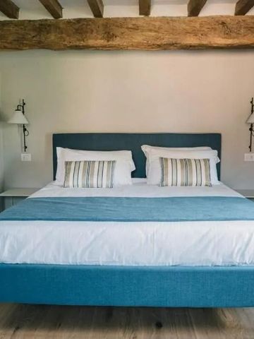 Doppelbett in einem Zimmer mit freiliegendem Holzbalken an der Decke