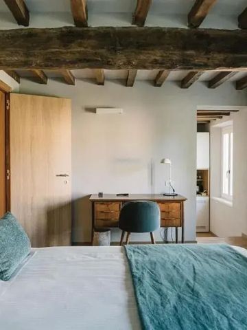 Einladendes Zimmer mit Holzbalkendecke und modernem Schreibtisch