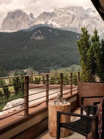Balkonblick auf beeindruckende Berglandschaft mit grünen Wäldern.