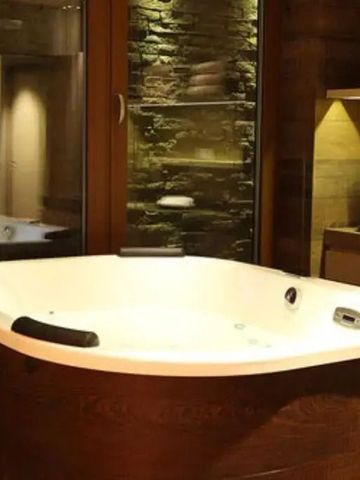 Whirlpool in einem stilvollen Spa-Ambiente mit warmem Licht.