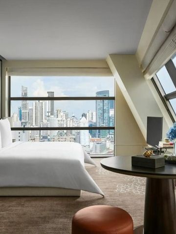 Luxuriöses Hotelzimmer mit Panoramafenstern und Ausblick auf die Skyline von Bangkok