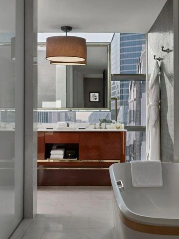 Luxuriöses Badezimmer mit freistehender Badewanne und Stadtblick