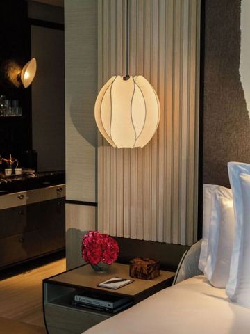 Moderne Nachttischlampe neben einem gemütlichen Bett in Hotelzimmer