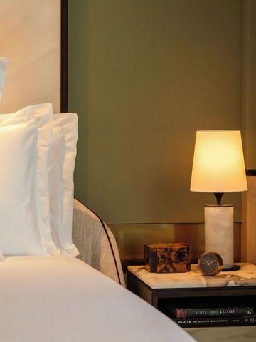 Bequemes Bett mit weichen Kissen und moderner Nachttischlampe