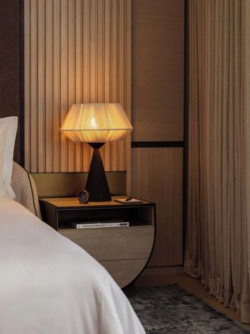 Schlafzimmeransicht mit eleganter Lampe und sanften Vorhängen