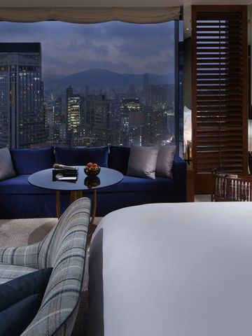 Stilvolles Hotelzimmer bei Nacht mit Blick auf die beleuchtete Stadt