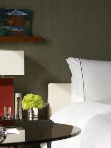 Elegantes Schlafzimmer mit modernem Design und Kunstwerk im Hintergrund