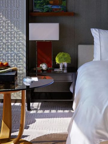 Gemütliche Zimmeransicht mit elegantem Nachttisch und Beleuchtung