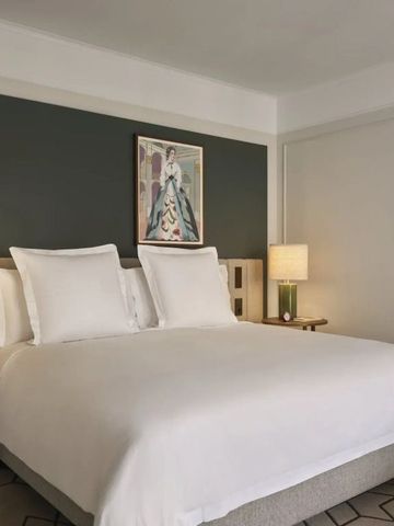 Gemütliches Hotelzimmer mit modernem Kunstwerk und luxuriösem Doppelbett.