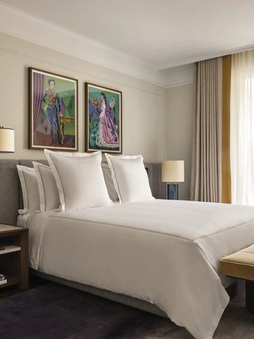 Helles Hotelzimmer mit stilvoller Einrichtung und Kunstwerken an der Wand.