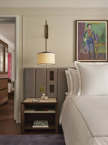 Detailansicht eines Hotelzimmers mit luxuriösem Bett und Kunstwerken