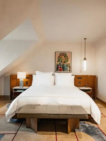 Geräumiges Dachzimmer mit großem Bett und moderner Dekoration