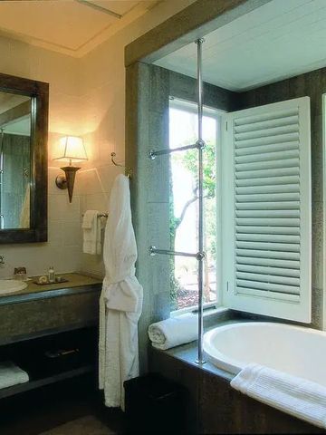 Elegantes Badezimmer mit Badewanne, großem Spiegel und Naturstein-Akzenten