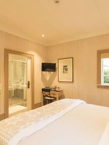 Komfortables Hotelzimmer in warmen Tönen mit Fernseher und Schreibtisch