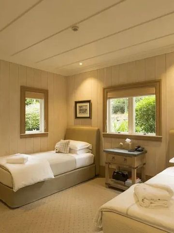 Gemütliches Hotelzimmer mit zwei Einzelbetten und Holzwänden