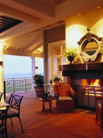 Stimmungsvolle Veranda mit Kamin und stilvollen Sitzmöglichkeiten